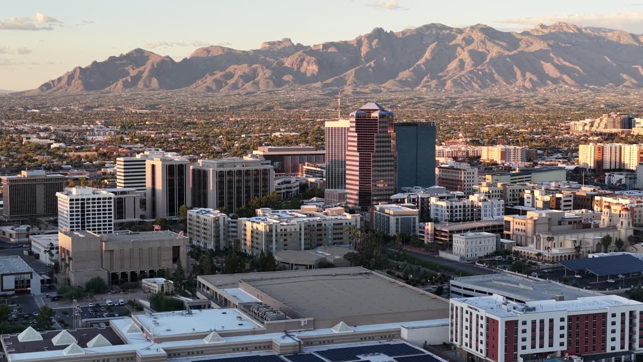 Wide circling shot of downtown Tucson, Arizona close to sunset with Catalina Mountains in the background