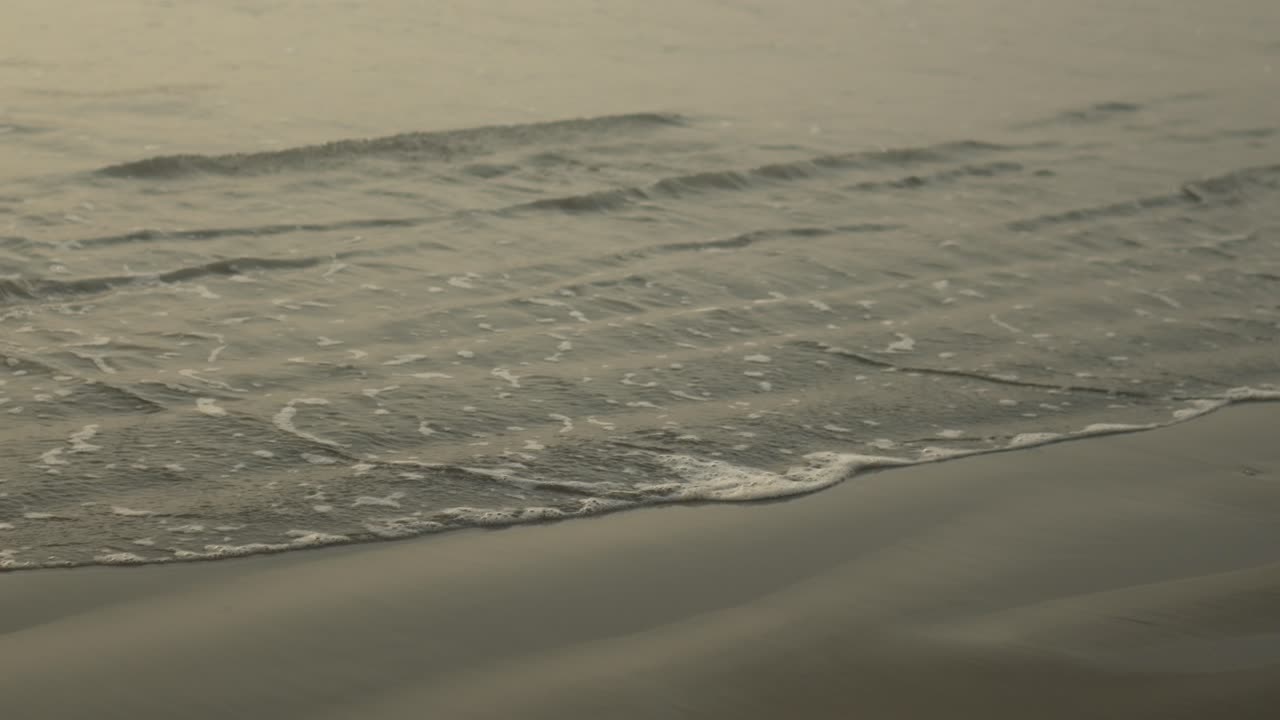 해가 지면 조용한 해변에 부드러운 파도가 부히고