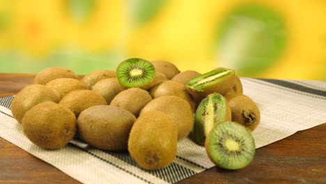 fruta de kiwi madura entera y media en un mantel blanco