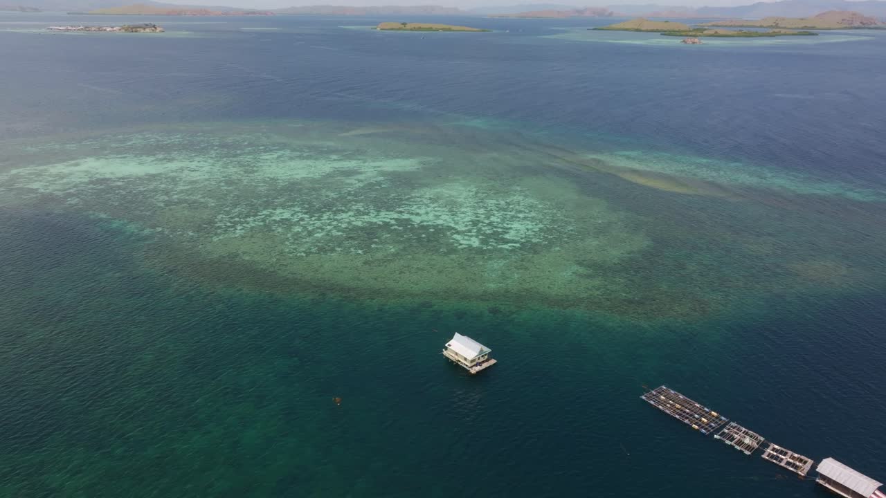 Ripresa aerea dell'oceano turchese che circonda una casa isolata, Indonesia