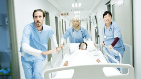 Three-healthcare-workers-urgently-pushing-hospital-bed-down-corridor-in-an-emergency-4k