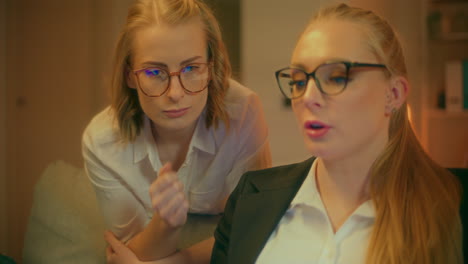 two female coworkers discuss new business idea during evening meeting