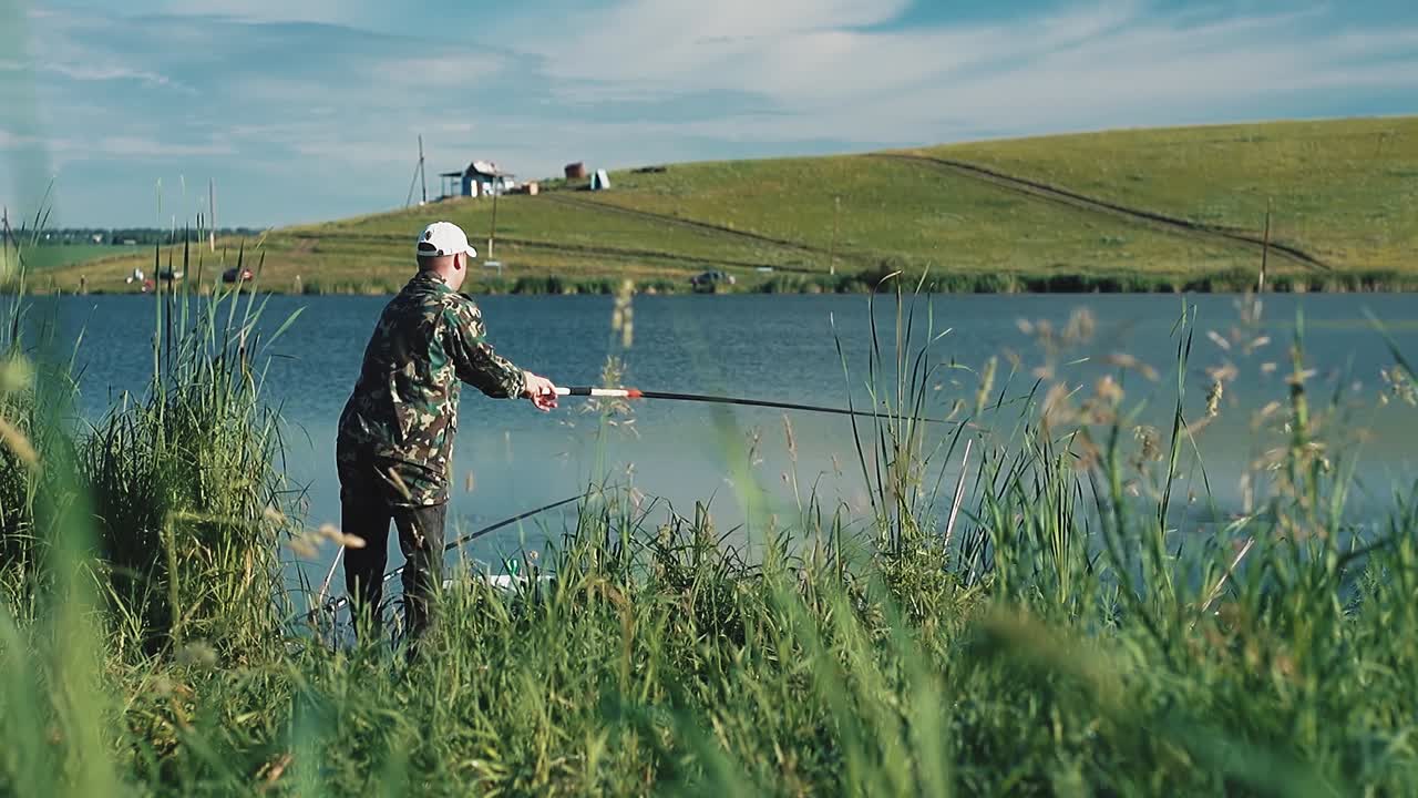рыбак выложил линию с рыболовной палкой в озеро.