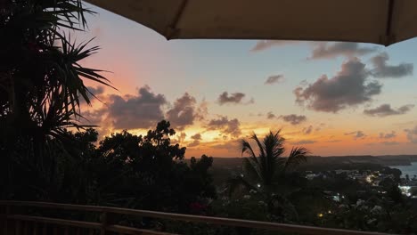 Tilt-up-shot-of-an-incredible-tropical-golden-and-pink-sunset-from-a-high-lookout-of-the-famous-tourist-beach-town-of-Pipa,-Brazil-in-Rio-Grande-do-Norte-during-a-warm-summer-evening