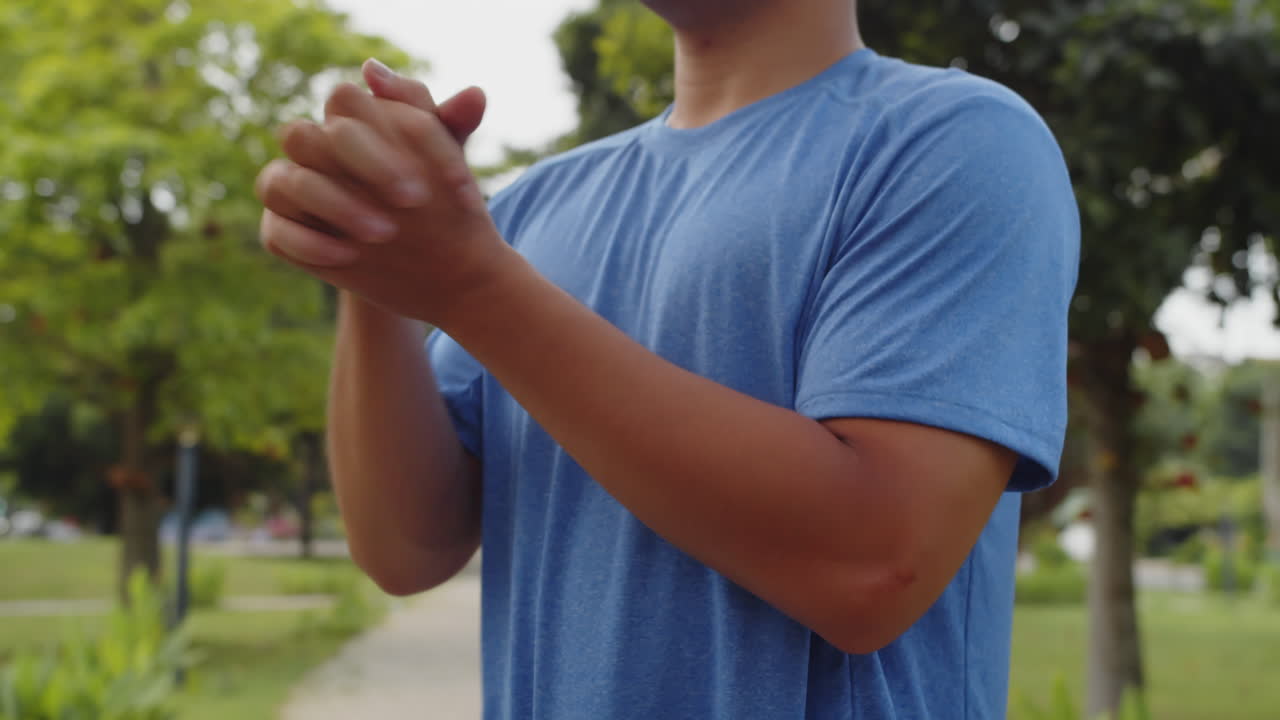 Male Athlete Stretching Wrists and Doing Neck Warm Up Outdoors