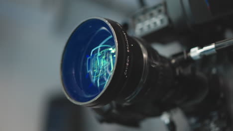 close up cinema lens reflecting vibrant green and blue led studio lights, revealing intricate glass elements and focus ring details, highlighting precision optics and coating