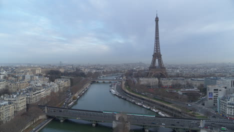 drone shot of paris eiffel tower with subway passing by