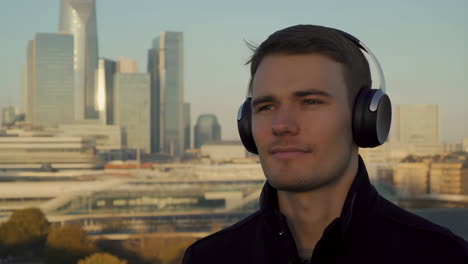 man listening to music with cityscape in background