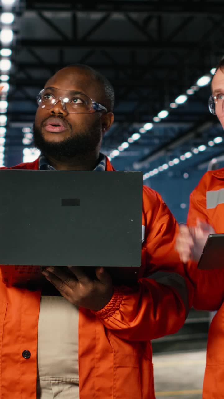 Vertical Video Colleagues use laptop and tablet to guide personnel during fabrication