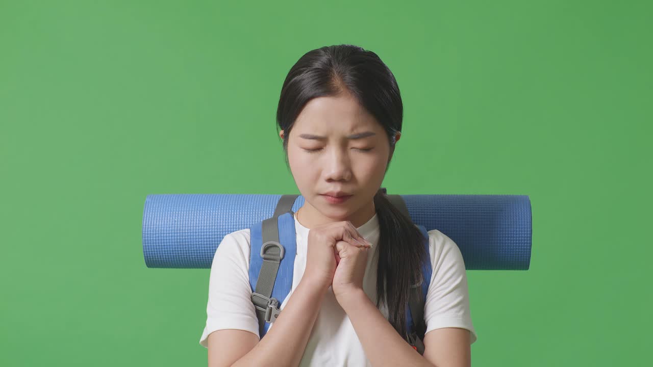 배 과 요가 매트 를 들고 기도 하는 젊은 여자