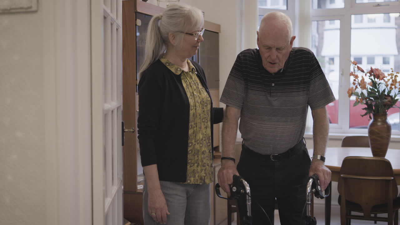 Elderly man with walker and caregiver at home