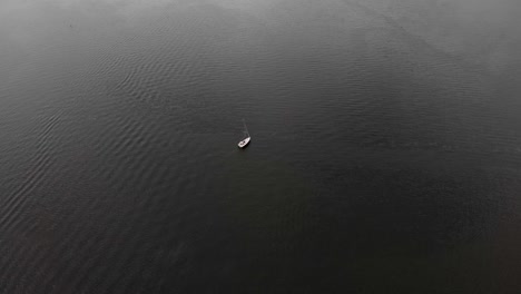 Luftaufnahme-Eines-Segelboots,-Das-Im-Ruhigen-Wasser-Des-Sees-Schwimmt