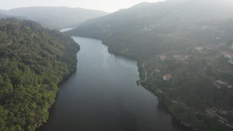 aerial view moving over douro river and mazouco village in northern portugal