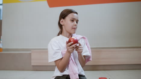 schoolgirl eating an apple.