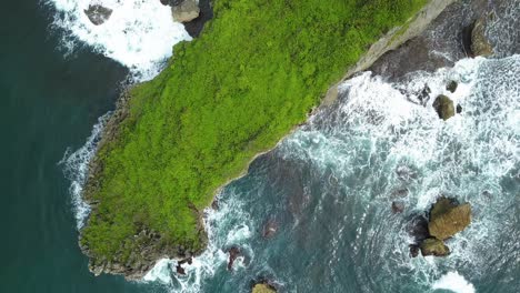 Vista-Aérea-De-Exuberantes-Acantilados-Verdes-Y-Olas-Rompiendo-En-La-Costa-De-Roca-Coralina