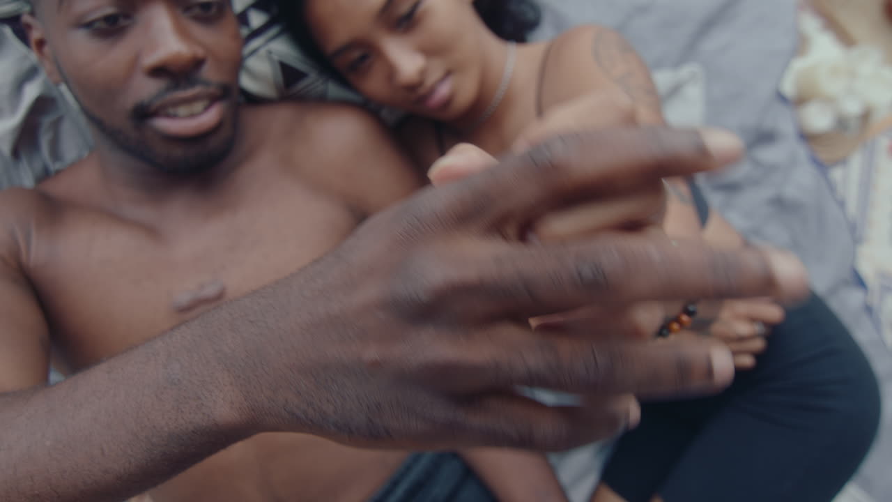 Couple in Love Touching Hands and Lying Down on Bed