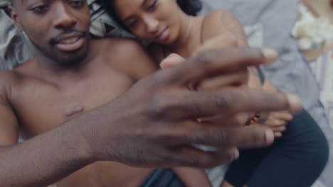 couple in love touching hands and lying down on bed