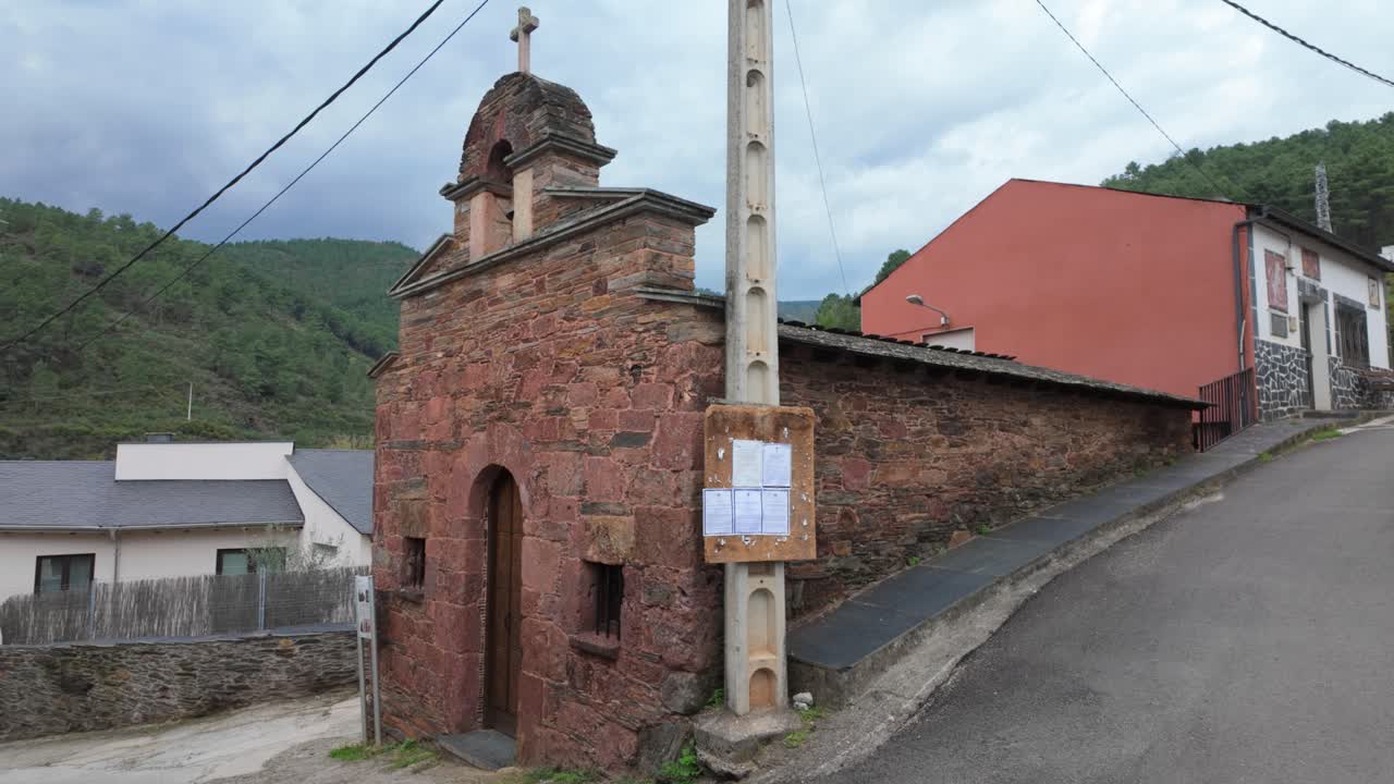 Exterior of San Lorenzo de Somoza chapel in A Rúa, Galicia, Spain, with stone facade and cross