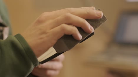 a carpenter is grinding a piece of wood, a plywood product made on a cnc laser machine using sandpaper