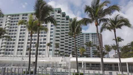 Hohe-Weiße-Gebäude-Mit-Palmen-Unter-Einem-Strahlend-Blauen-Himmel-In-Miami-Beach