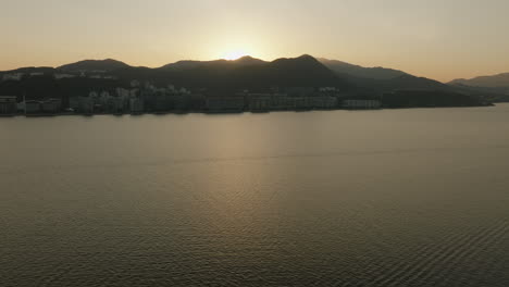 silhouette of hong kong cityscape with skyscraper during epic sunset over the ocean water