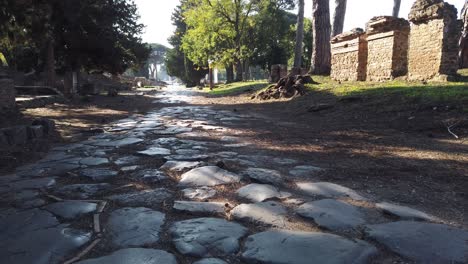 roman road covered with stone blocks at the entrance of ostia antica, a world famous archeological site