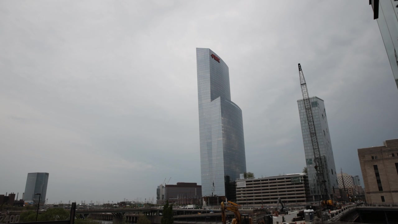 Modern skyscrapers, including the fmc tower, dominating the philadelphia skyline under a grey, cloudy sky with a large construction site in the foreground showcasing urban development