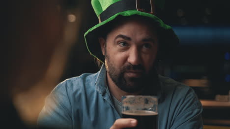 portrait d'un homme au chapeau irlandais parlant avec des amis dans un pub