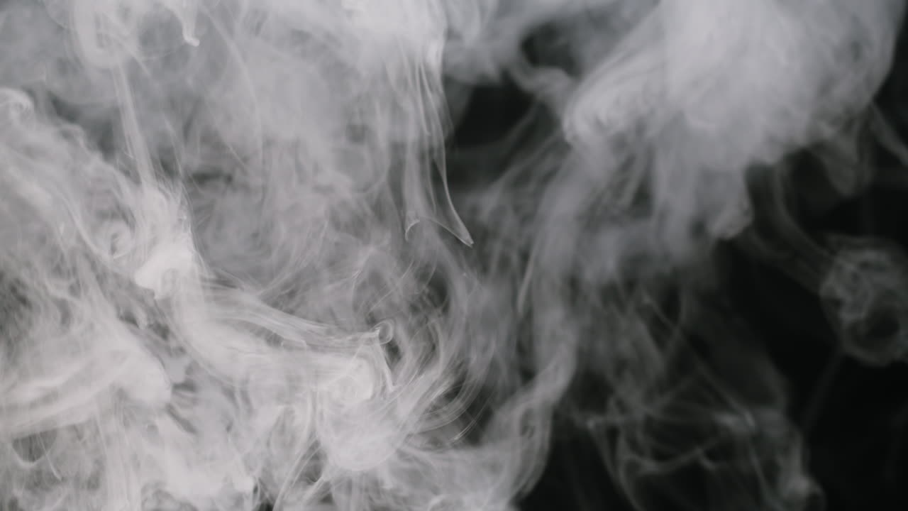 White Smoke Rising and Swirling on Black Background in Slow Motion