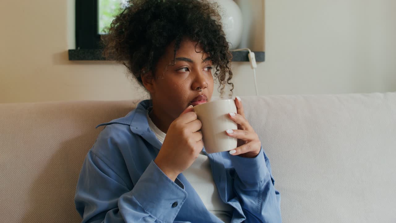 Woman relaxing with a cup of coffee on the sofa