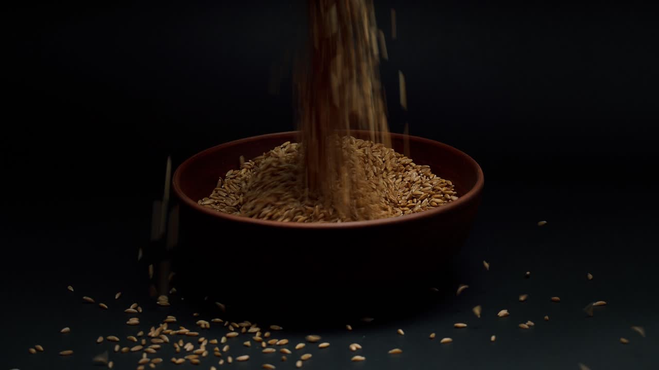 Hands Scooping and Pouring Grains into a Bowl