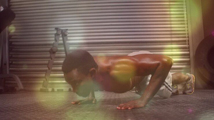 From high plank, man doing push-ups on rubber mat, lighting flares showing flex, building fitness