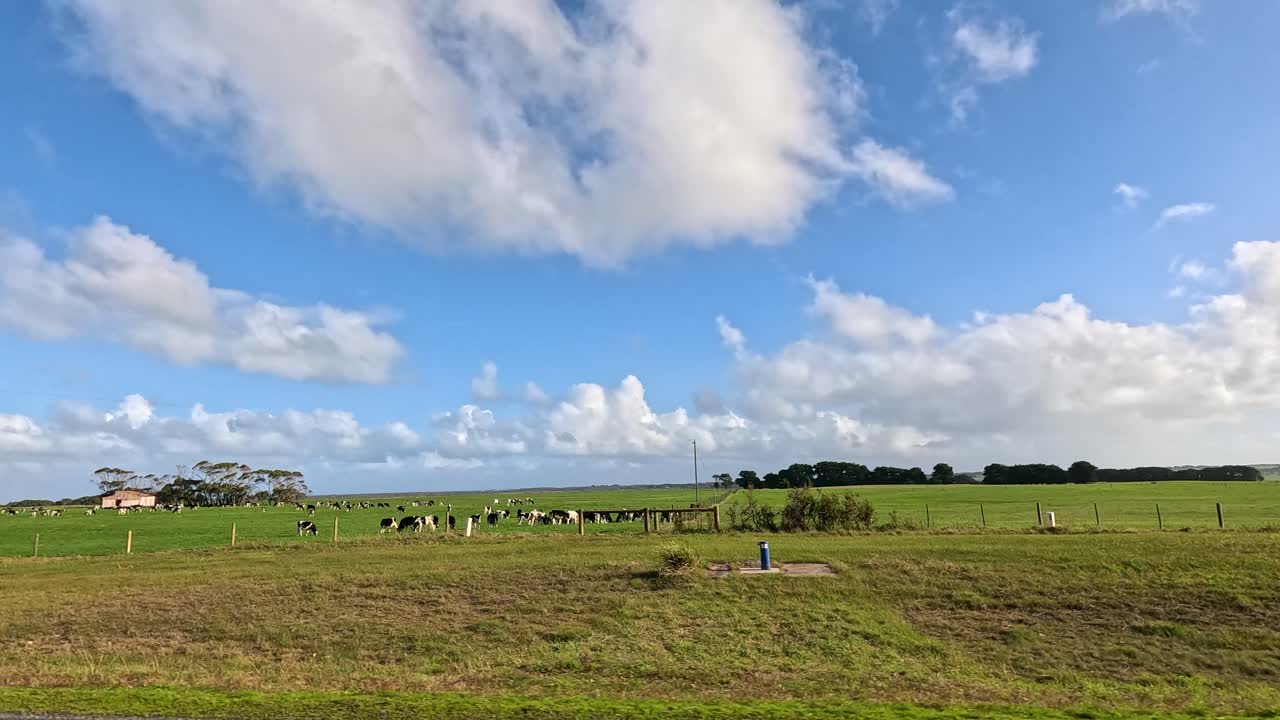 campos verdes exuberantes e estruturas agrícolas sob céus azuis