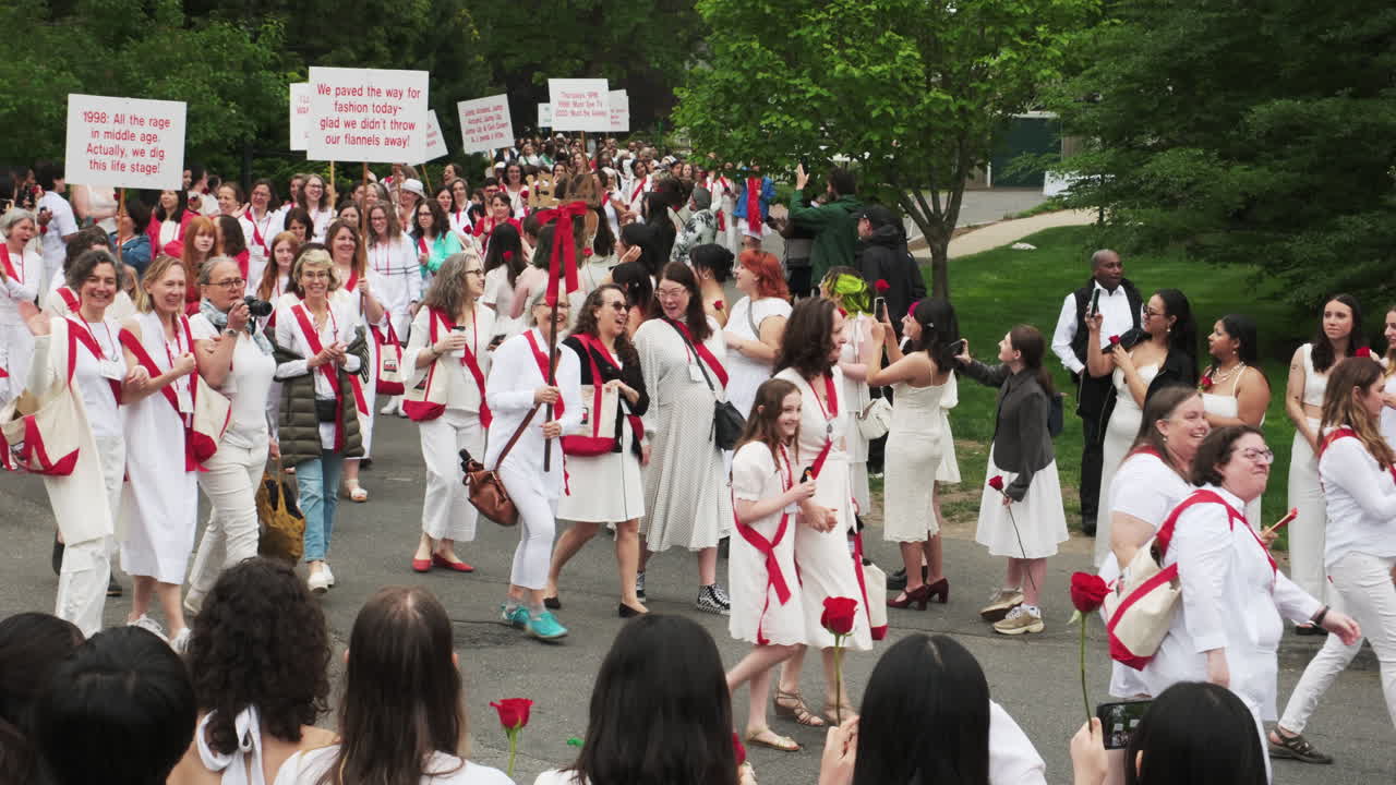 A vibrant wave of red and white as the spirited class of 1974 marches triumphantly in the historic Smith College Ivy Day Commencement procession