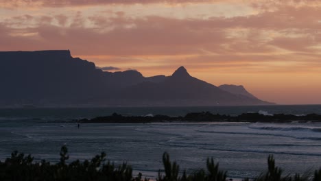 Orilla-De-La-Playa-Con-Vista-Al-Atardecer-Y-Fondo-De-La-Montaña-De-La-Mesa