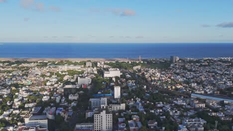 an aerial perspective of chennai in the morning would showcase the city's tranquil beauty, as the sun casts a golden glow over its sprawling urban landscape. marina beach with city view.