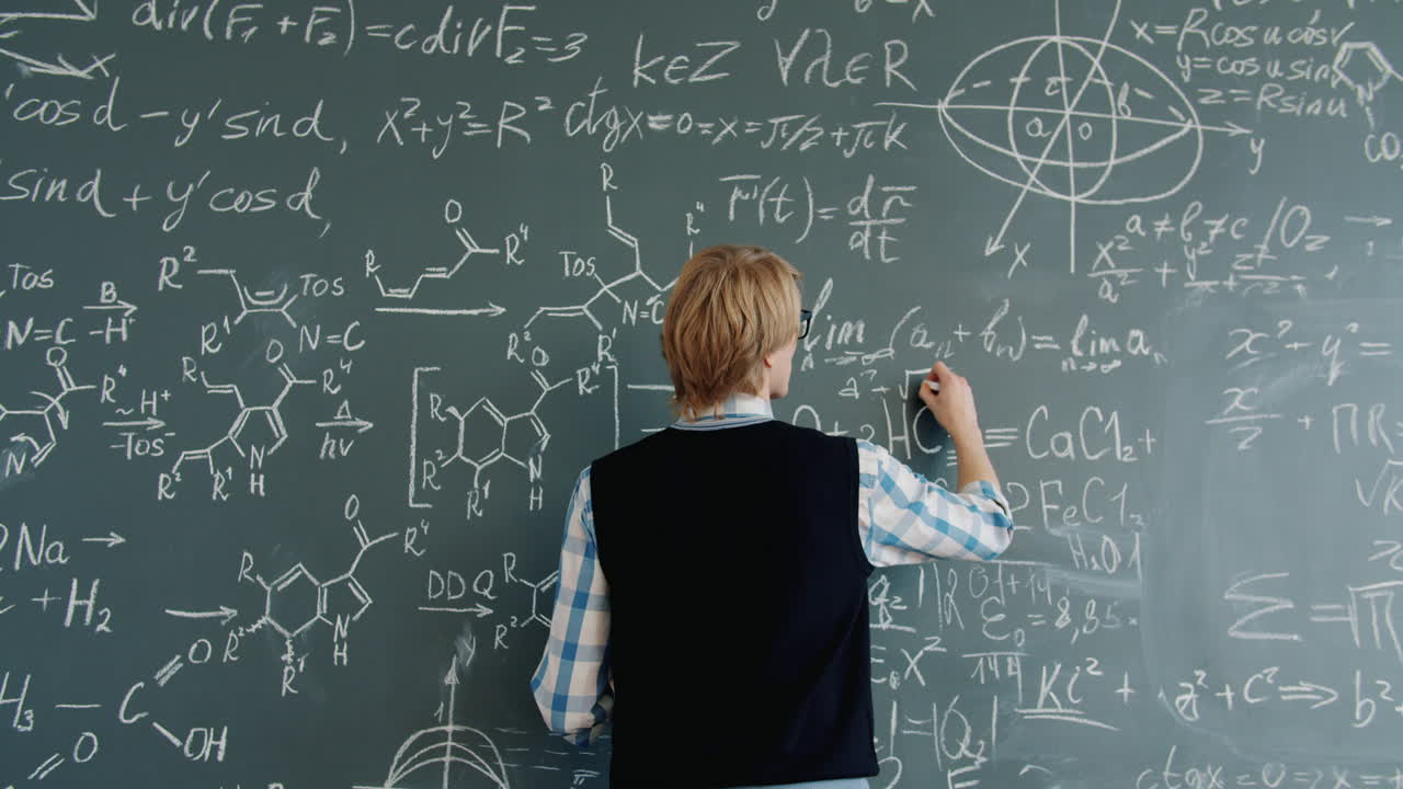 Student writing equations on a chalkboard