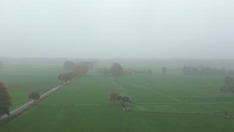 aerial footage of a foggy farmland in autumn colors