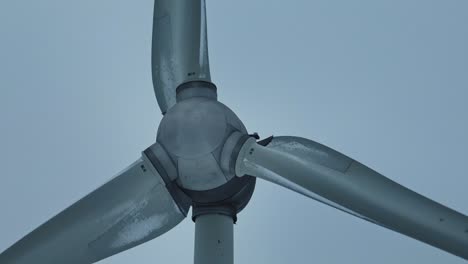 up close, wind turbine blades spin and generate electricity for consumers