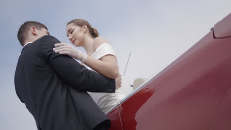 una pareja besándose en un coche vintage rojo