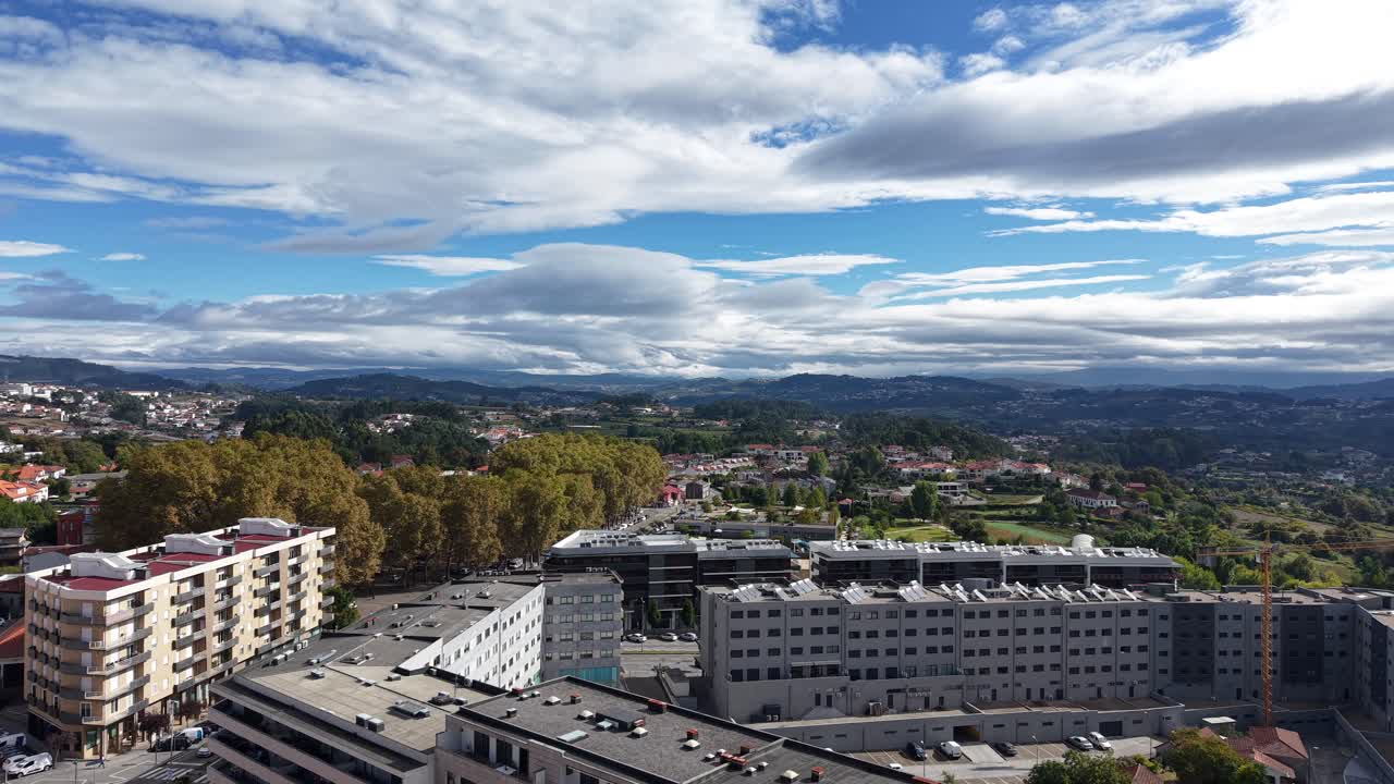 Edificios modernos del pueblo de Lousada rodeados de colinas verdes y nubes