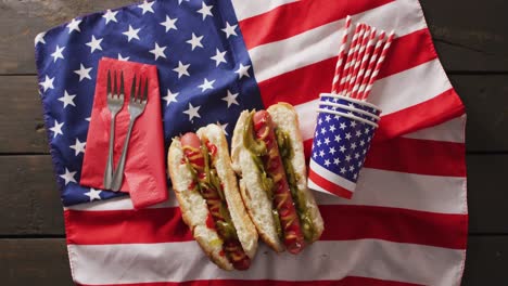 video of hot dogs with mustard and ketchup over flag of usa on a wooden surface