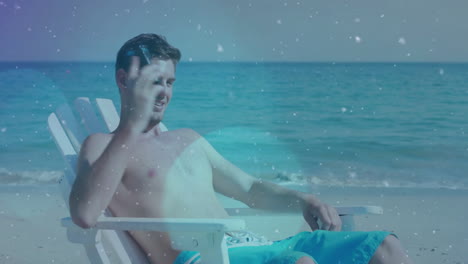 relajándose en una silla de playa, hombre usando un teléfono inteligente con animación de nieve sobre el fondo del océano