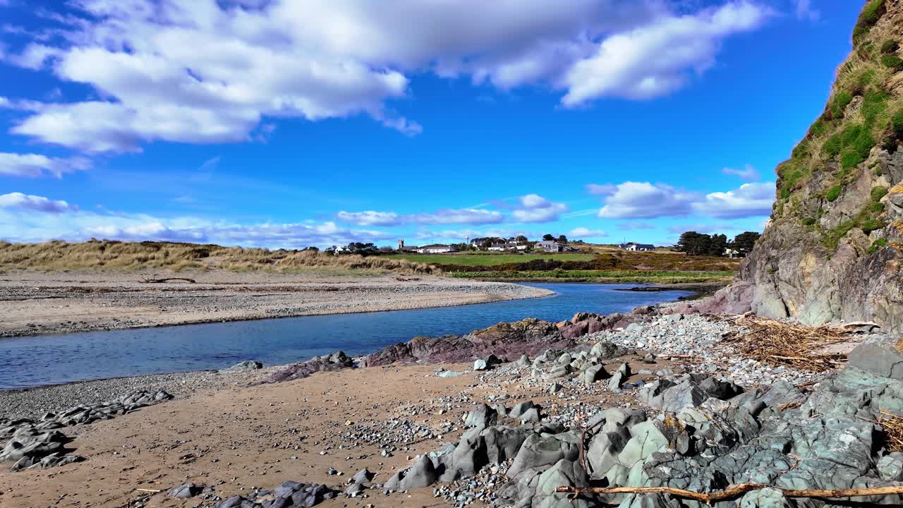 Ireland Epic Locations Mahon rive entering the sea with Bunmahon Village in background spring afternoon