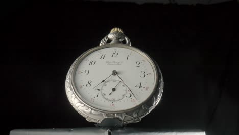 close-up of an ornate vintage pocket watch with white dial
