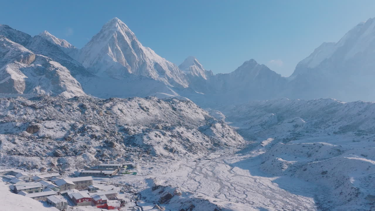 Aerial drone view of Everest Base Camp trek in Khumbu, Nepal. Morning snowfall reveals Lobuche Sherpa village with Himalayan houses beneath Pumori and Lhotse peaks, a peaceful and calming scene