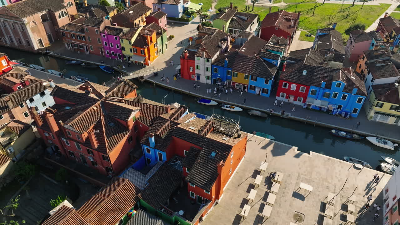 Aerial drone view of boats on the sides of a canal near the colourful houses of Burano Island, Italy