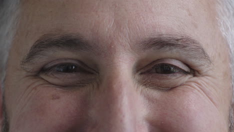 close up mature man opening eyes looking at camera smiling happy healthy eyesight