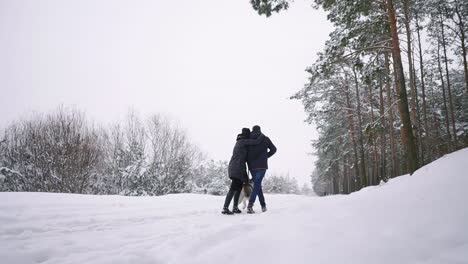 Loving-Man-and-woman-walking-with-Siberian-husky-in-winter-forest-smiling-and-looking-at-each-other-Slow-motion-happy-family.-The-view-from-the-back