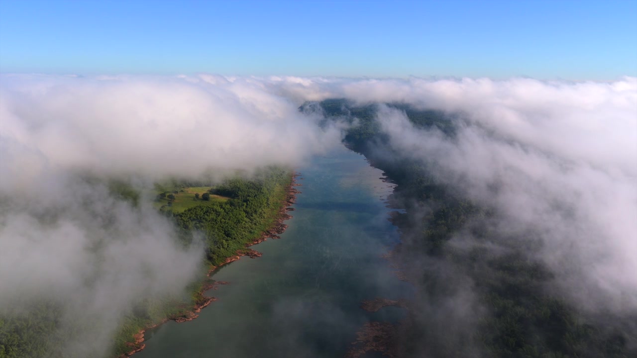 Aerial view of the Parana River cutting through dense morning clouds along the natural border between Argentina and Paraguay.